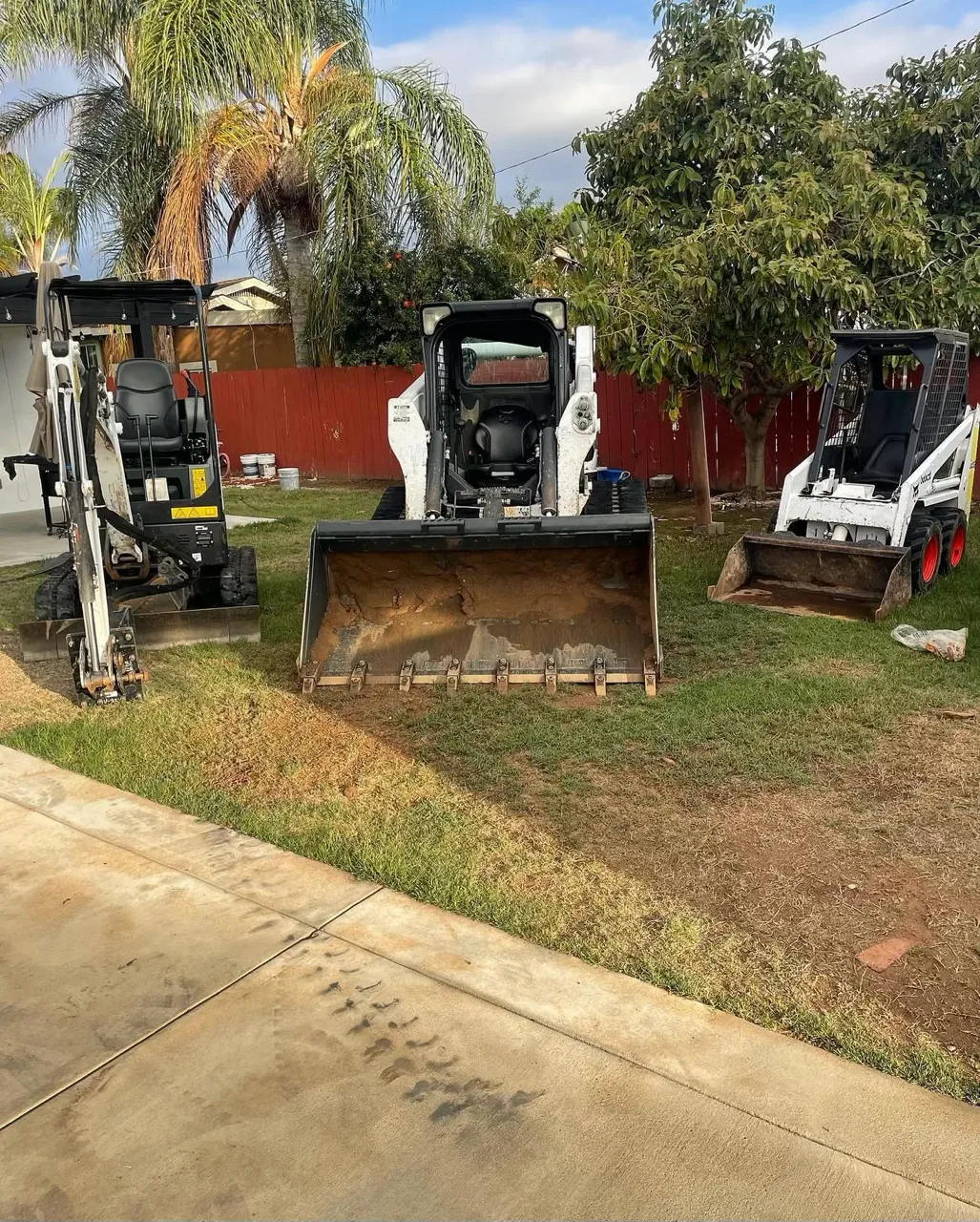 Bobcat E20 mini excavator, Bobcat T770 skid steer, and mini skid steer lined up together, ready for rental in San Diego