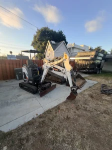 Bobcat E20 excavator bucket with teeth ready to dig in a tight-access backyard job in San Diego