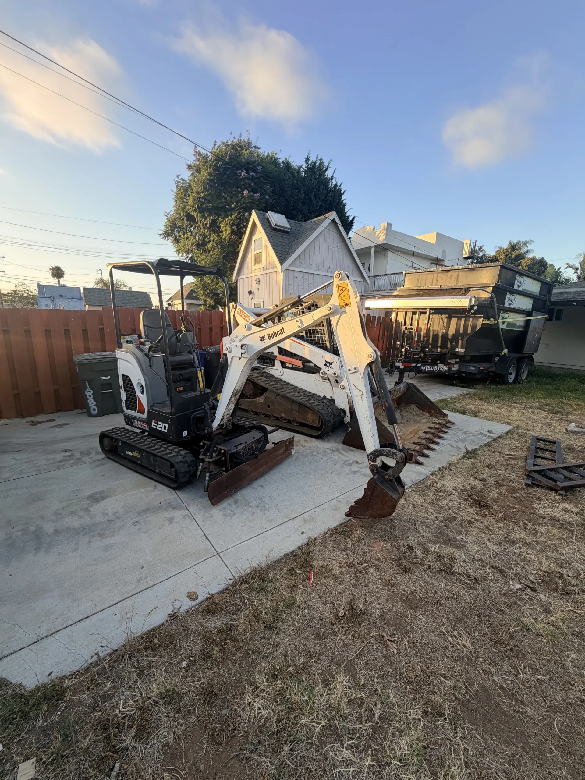 Bobcat E20 excavator bucket with teeth ready to dig in a tight-access backyard job in San Diego