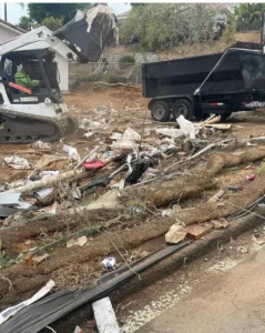 Bobcat T770 loading construction and yard debris into a dump trailer on a San Diego job site