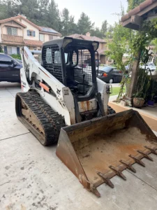 Bobcat T770 compact track loader grading soil in a San Diego backyard project